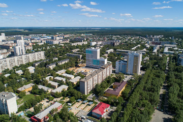 Top down aerial drone image of a Ekaterinburg with low houses and new high-rise buildings. Midst of summer, backyard turf grass and trees lush green.