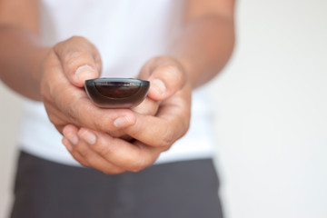Man hand switches TV channels. Remote control in hand