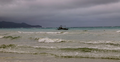 Fishing boat on waves 