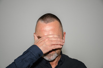 Man covering his eyes with one hand