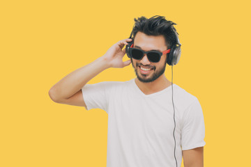 Asian handsome man with a mustache, smiling and laughing and using smart phone to listen music with...