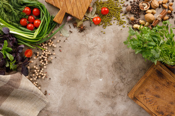 Fresh greens and tomatoes cereals spices and nuts organic healthy snacks on a textural background. The concept of healthy eating. Lean foods. Copy space.