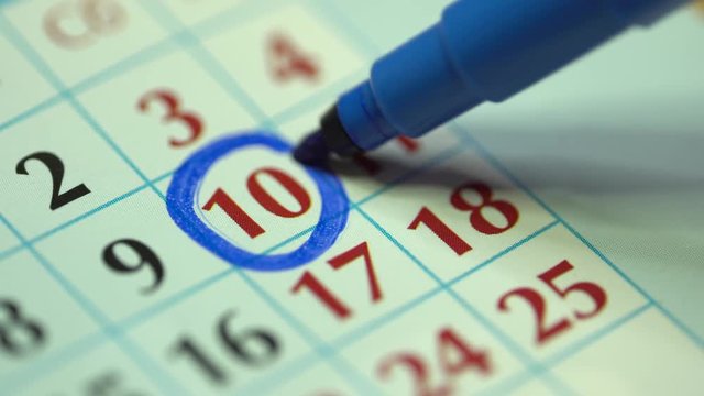 10. The tenth day of the month. Marking the date in the calendar with a blue marker