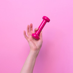 Woman hand holding pink dumbbell