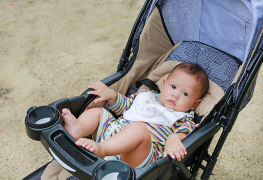 6 months little Asian baby boy sitting in the stroller