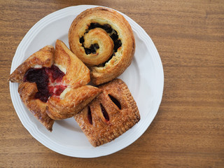 Three Viennoiserie Pastries on a White Plate