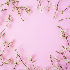 Fototapeta na wymiar Floral frame with spring flowers on pink background. Flat lay, top view