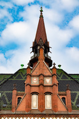 Tower of an old church builded with red brickstones under blue sky