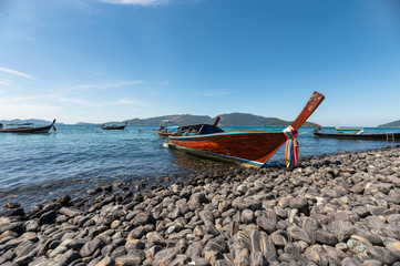 Obraz premium Wooden long-tail boat anchored on koh hin-ngam coastline