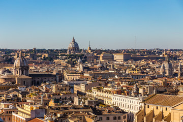 Fototapeta na wymiar Panoramic sight from the heights with the dome and rooftops of the eternal city in Rome, Italy