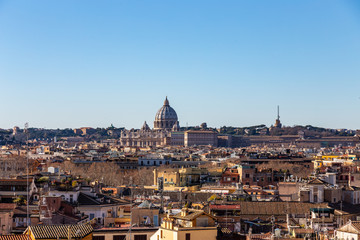 Fototapeta na wymiar Panoramic sight from the heights with the dome and rooftops of the eternal city in Rome, Italy