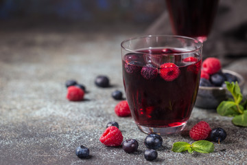 Berry drink with fresh blueberries and raspberries, berry ice lemonade in a glass