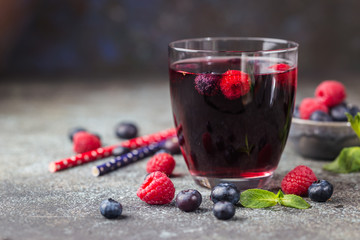 Berry drink with fresh blueberries and raspberries, berry ice lemonade in a glass