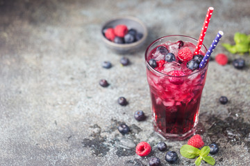 Berry drink with fresh blueberries and raspberries, berry ice lemonade in a glass