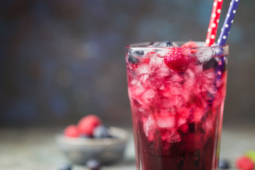 Berry drink with fresh blueberries and raspberries, berry ice lemonade in a glass