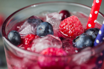 Berry drink with fresh blueberries and raspberries, berry ice lemonade in a glass