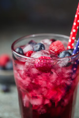 Berry drink with fresh blueberries and raspberries, berry ice lemonade in a glass