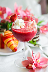 strawberry smoothie in a glass with whipped cream. healthy breakfast strawberry smoothie