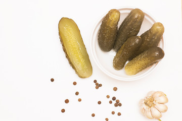 Marinated pickled cucumbers in bowl. Top view, white background