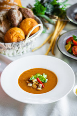 Mexican lunch, gazpacho soup with crackers and hot peppers in a white plate. tomato soup with vegetables. mexican soup. Puree soup tomato with croutons. Diet menu. tomato soup in a white plate