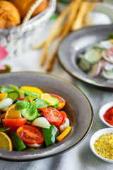 fresh salad of tomato cucumber pepper onion lemon and greens. healthy salad with fresh ripe summer vegetables