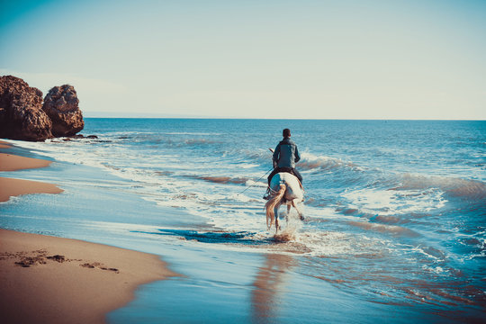 Young Man Ride A White Horse On The Beach