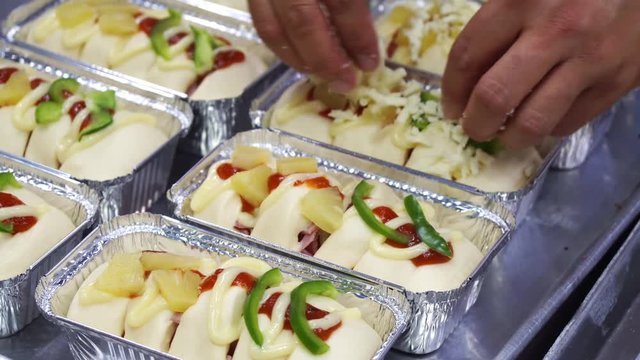 Chefs are sprinkling toppings on toast, ham pizza on a tray Freud.