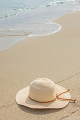 Fototapeta na wymiar Top view of sandy beach with summer hat. Blank mock up for advertising or packaging.