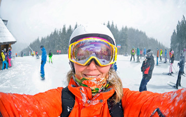 Happy woman taking selfie on winter  in Carpathian Mountains, Bukovel , Ukraine