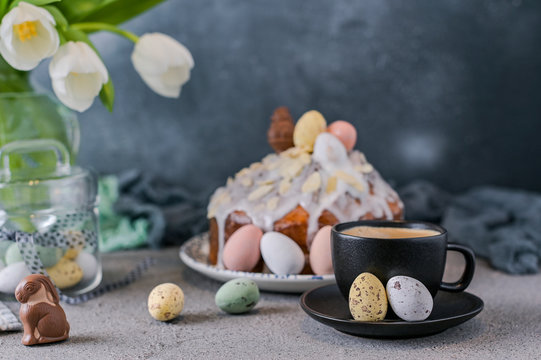 Fragrant cup of coffee and Easter orthodox sweet bread, kulich and colorful quail eggs with willow branches. Holidays breakfast concept with copy space. Retro style.