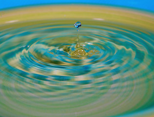Fototapeta na wymiar Drop of water or fluid created a ripple wave and a corona.