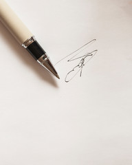 pen with signature and document in background