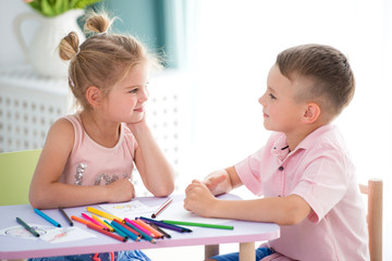Little children play and draw with colorful pencils