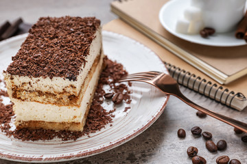 Plate with tasty tiramisu on grey table