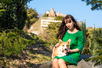 young woman palys with cute welsh corgi puppy