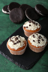 Slate plate with tasty muffins on table