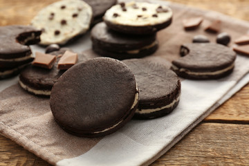 Obraz na płótnie Canvas Napkin with tasty chocolate cookies on wooden table