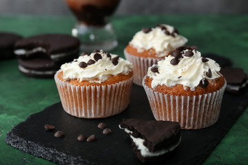 Slate plate with tasty muffins on table