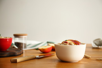Bowl with tasty sweet oatmeal on wooden table