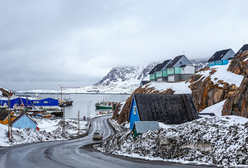 Acrtic road to the docks and port between the rocks with Inuit houses, Sisimiut, Greenland