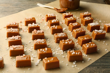 Tasty salty caramel candies on parchment