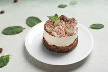 Plate with tasty tiramisu on light background