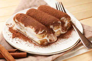 Plate with tasty tiramisu on wooden table