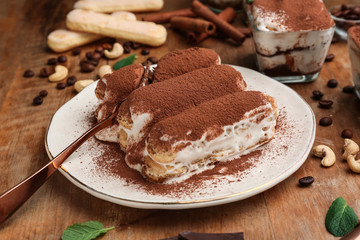 Plate with tasty tiramisu on wooden table