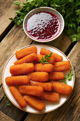 Plate with tasty mozzarella sticks and jam on wooden table