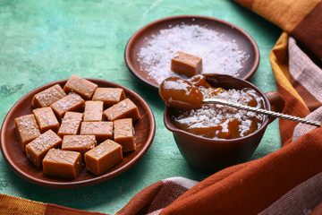 Candies with salted caramel on color background