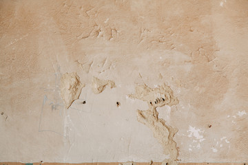 Textured wall of the old house. The texture of old cracked concrete with paint.