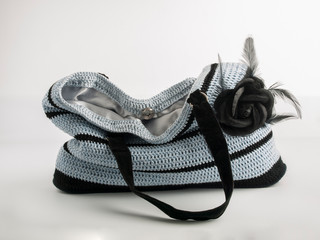 Women's accessories: black and blue striped knitted bag on a white background. Handmade. Fashion. Advertising