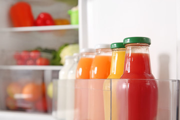Bottles with milk and juice in open fridge