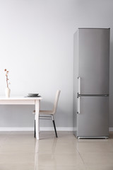 Modern fridge and served table in kitchen